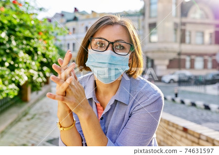 Outdoor portrait of business mature woman in medical protective mask Outdoor portrait of business mature woman in medical protective mask 74631597
