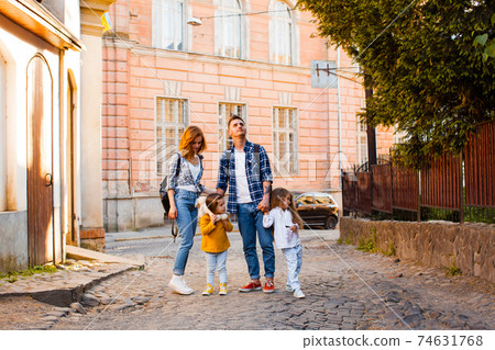 The family are walking around the old town at the summer The family are walking around the old town at the summer 74631768