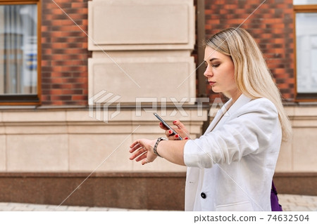 Young business woman walking in city talking on mobile phone 74632504