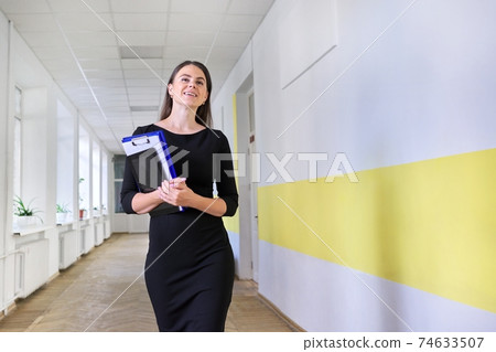 Portrait of young smiling female teacher at school Portrait of young smiling female teacher at school 74633507