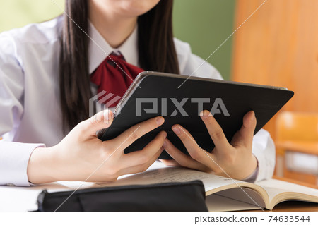 在平板電腦上學習的高中女生高中學生 在平板電腦上學習的高中女生高中學生 74633544