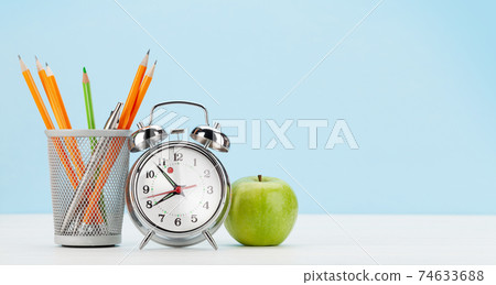 Office desk with alarm clock, apple and supplies. Work from home Office desk with alarm clock, apple and supplies. Work from home 74633688