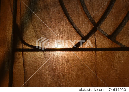 sunlight through old curtain and wrought iron curve on window frame sunlight through old curtain and wrought iron curve on window frame 74634030