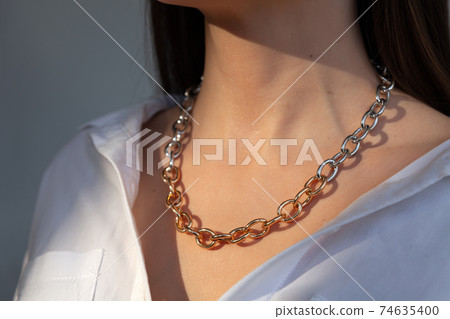 Beautiful model brunette in modern gold metal necklace chain 74635400