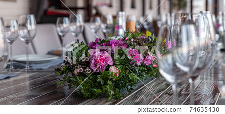 Modern veranda restaurant interior, flowers, banquet setting, glasses, plates Modern veranda restaurant interior, flowers, banquet setting, glasses, plates 74635430