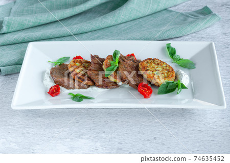 Fried grilled slices of beef fillet with vegetable zucchini and cabbage pancakes 74635452