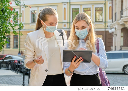 Business women wearing medical protective masks with digital tablet Business women wearing medical protective masks with digital tablet 74635581
