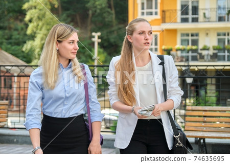 Business people, young talking office women employees walking together 74635695