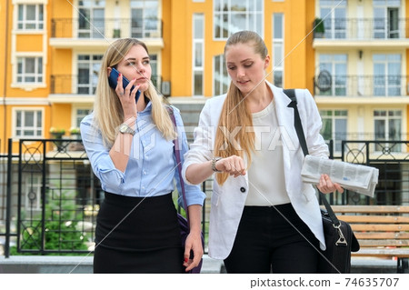 Business people, young talking office women employees walking together Business people, young talking office women employees walking together 74635707