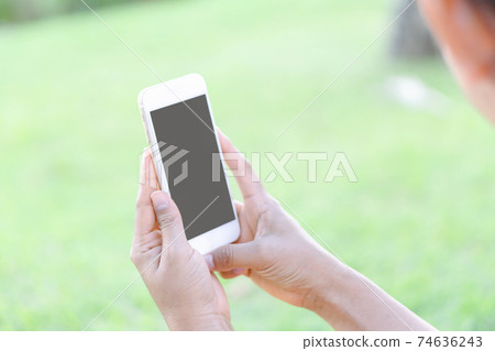 Closeup woman hand playing smartphone mobile with relaxing feelling, selective focus 74636243