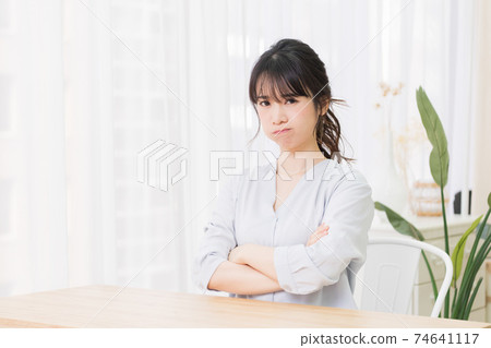 Young woman making an angry gesture in the room 74641117