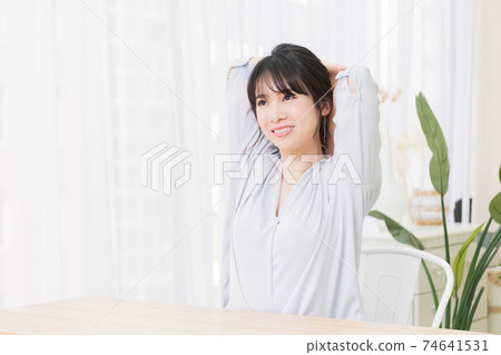 一個年輕的女人在房間裡伸展 74641531