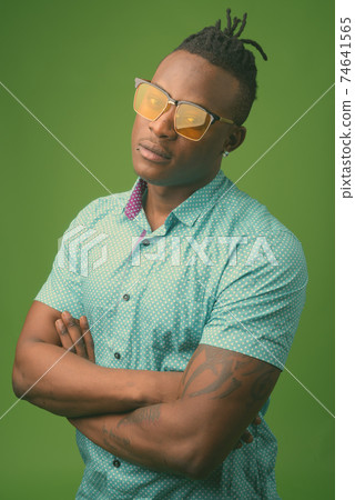 Young handsome African man from Kenya against green background Young handsome African man from Kenya against green background 74641565