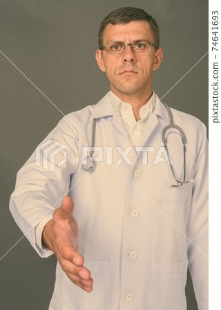 Handsome man doctor with short hair against gray background 74641693