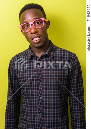 Portrait of young African hipster man sticking tongue out 74642432