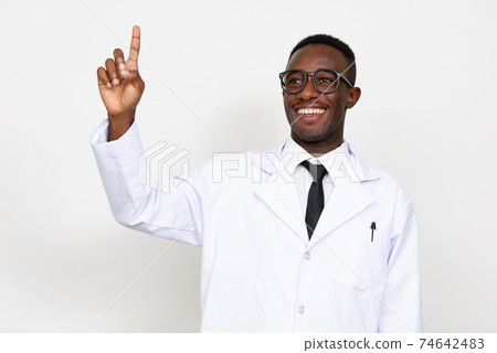 Portrait of happy young African man doctor pointing up Portrait of happy young African man doctor pointing up 74642483
