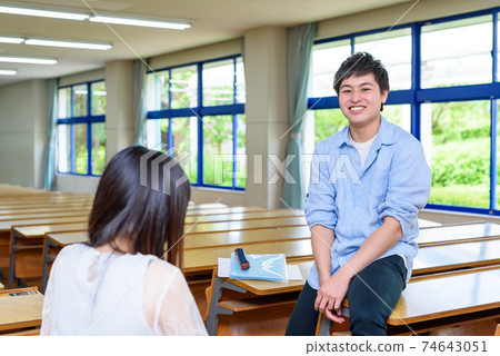 Male and female college students discussing in a college classroom Male and female college students discussing in a college classroom 74643051