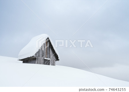Wooden cabin covered with snow Wooden cabin covered with snow 74643255