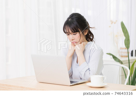 一個女人在房間裡使用筆記本電腦時擔心 74643316