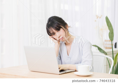 一個女人在房間裡使用筆記本電腦時擔心 74643318