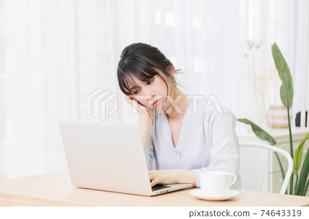一個女人在房間裡使用筆記本電腦時擔心 74643319
