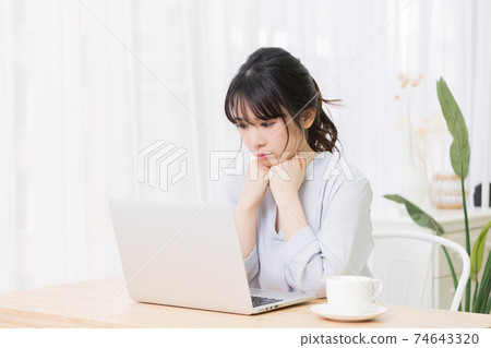 一個女人在房間裡使用筆記本電腦時擔心 74643320