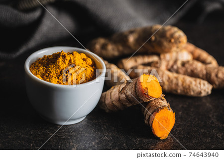 Indian turmeric powder and root. Turmeric spice. Ground turmeric. Indian turmeric powder and root. Turmeric spice. Ground turmeric. 74643940