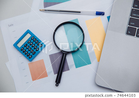 Accounting calculator, charts and magnifying glass. Business and finance concept 74644103