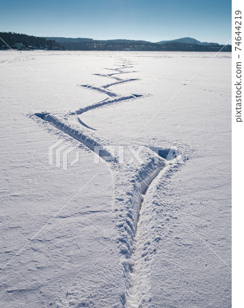 Fresh powder on the frozen Lake with traces of ice skaters. Fresh powder on the frozen Lake with traces of ice skaters. 74644219