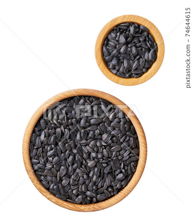 organic sunflowers seeds in a wooden bowl  isolated on a white background, top view. 74644615