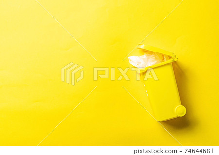 Precycling. Bin container for disposal garbage waste and save environment. Yellow dustbin for recycle plastic trash isolated on yellow background. 74644681