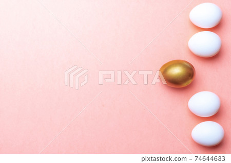 Easter background. Golden, white colour egg on pastel pink background in Happy Easter decoration. Spring holiday top view concept. Easter background. Golden, white colour egg on pastel pink background in Happy Easter decoration. Spring holiday top view concept. 74644683