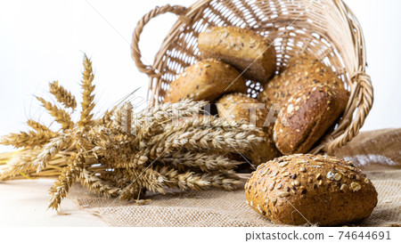 Rustic bread. Fresh loaf of rustic traditional bread with wheat grain ear or spike plant on linen texture background. Rye bakery with crusty loaves and crumbs. Concept - Cooking at Home. Rustic bread. Fresh loaf of rustic traditional bread with wheat grain ear or spike plant on linen texture background. Rye bakery with crusty loaves and crumbs. Concept - Cooking at Home. 74644691