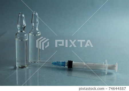 Vaccine in vial with syringe medicine blue background 74644887