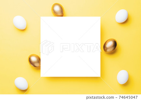 Easter egg hunt. Golden, white colour egg on pastel yellow background in Happy Easter decoration. Traditional design in top view. 74645047