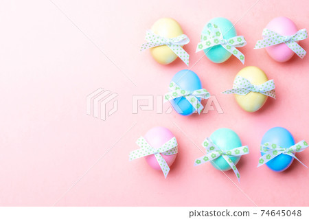 Easter card. Colorful egg with tape ribbon on pastel pink background in Happy Easter decoration. Flat lay, top view with copy space. Easter card. Colorful egg with tape ribbon on pastel pink background in Happy Easter decoration. Flat lay, top view with copy space. 74645048