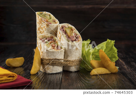 Doner kebab, shawarma with rustic potatoes and cabbage on a wooden textured background 74645303