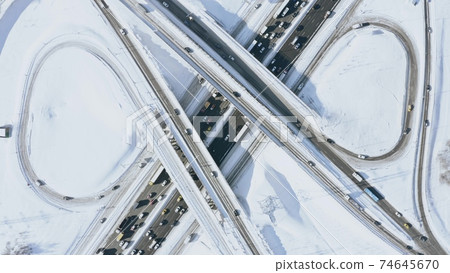 Aerial overhead shot of a busy motorway interchange and traffic jam in winter Aerial overhead shot of a busy motorway interchange and traffic jam in winter 74645670