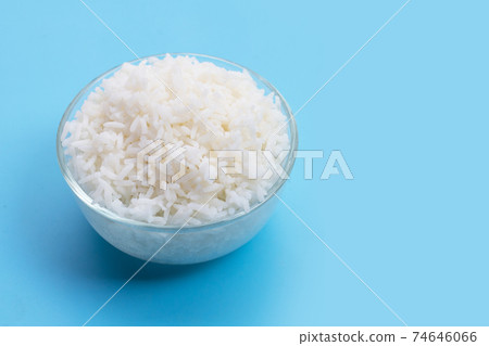 Glass bowl of rice on blue background. Glass bowl of rice on blue background. 74646066