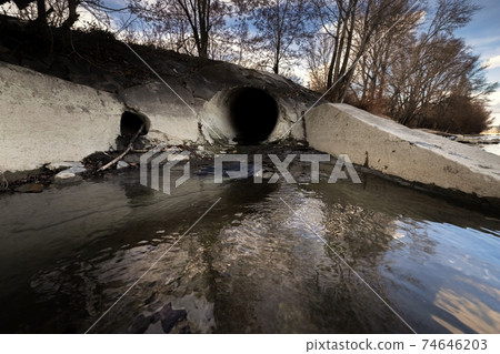 Large sewage tunnel with filth flowing out 74646203