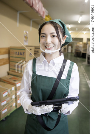 Female employee walking in the backyard of a supermarket Female employee walking in the backyard of a supermarket 74649602