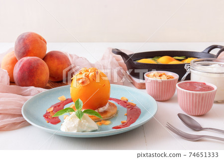 Roasted Peaches, tasty fresh fruit dessert with lemon, lime and basil creme fraiche and raspberry coulis. 74651333