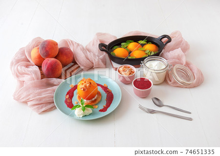 Roasted Peaches, tasty fresh fruit dessert with lemon, lime and basil creme fraiche and raspberry coulis. 74651335