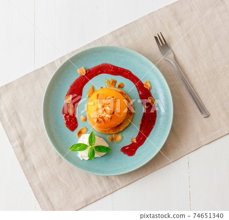 Roasted Peaches, tasty fresh fruit dessert with lemon, lime and basil creme fraiche and raspberry coulis. 74651340