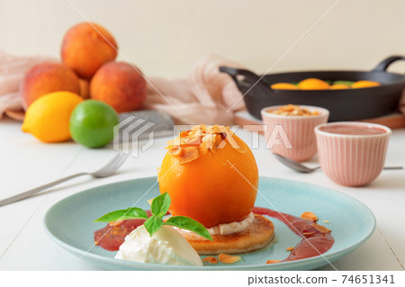 Roasted Peaches, tasty fresh fruit dessert with lemon, lime and basil creme fraiche and raspberry coulis. 74651341