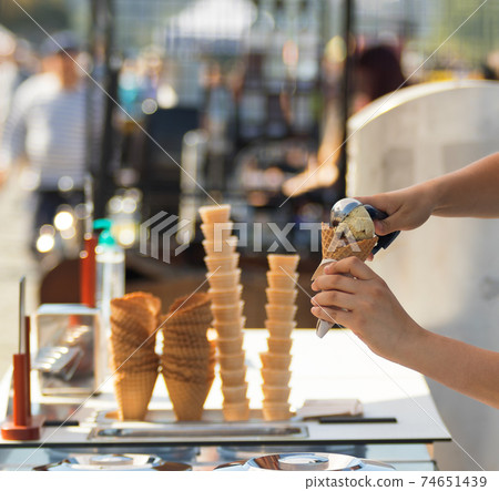 Female vendor sells ice cream at Naplavka farmers street food market in Prague, Czech Republic. Female vendor sells ice cream at Naplavka farmers street food market in Prague, Czech Republic. 74651439