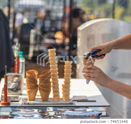 Female vendor sells ice cream at Naplavka farmers street food market in Prague, Czech Republic. Female vendor sells ice cream at Naplavka farmers street food market in Prague, Czech Republic. 74651440