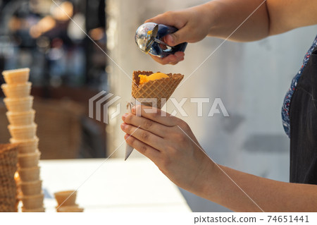 Female vendor sells ice cream at Naplavka farmers street food market in Prague, Czech Republic. Female vendor sells ice cream at Naplavka farmers street food market in Prague, Czech Republic. 74651441
