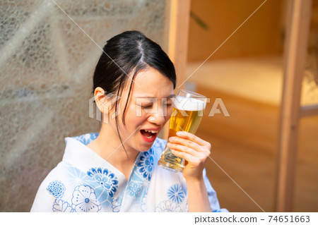 一個女人在浴衣中享受啤酒 一個女人在浴衣中享受啤酒 74651663