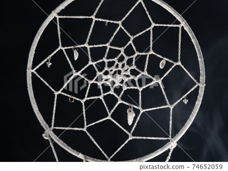 Mystical attribute dreamcatcher on a black background with smoke Mystical attribute dreamcatcher on a black background with smoke 74652059